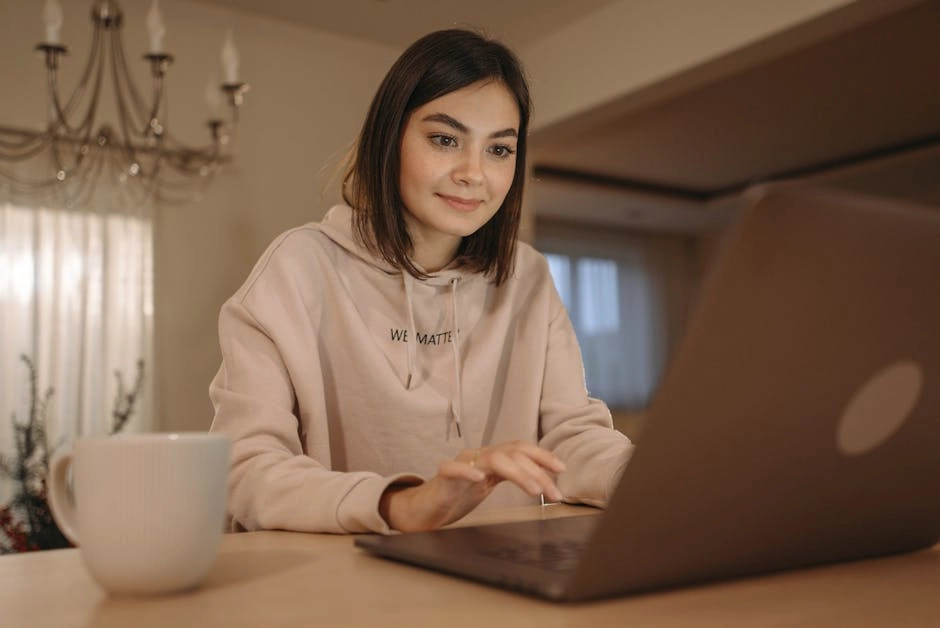 Person enjoying creative work on a laptop in a calm studio setting.